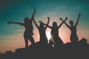 women dancing in front of sunset